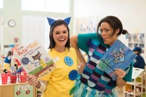 Kiddie Academy Pre-School teachers, Amy Sauers (left) and Brie Brown (right), dress up and pose with their favorite children's book in celebration of Read Across America Day