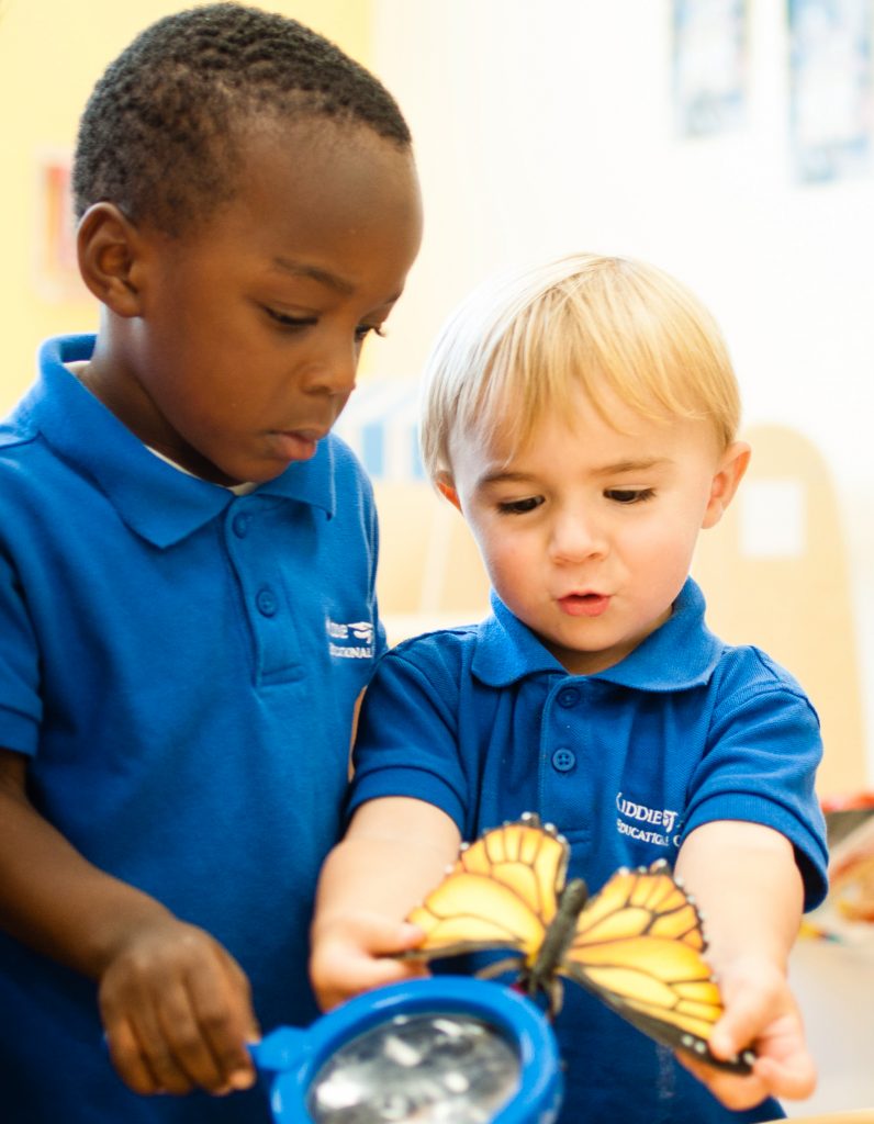 Kiddie Academy students examining a butterfly